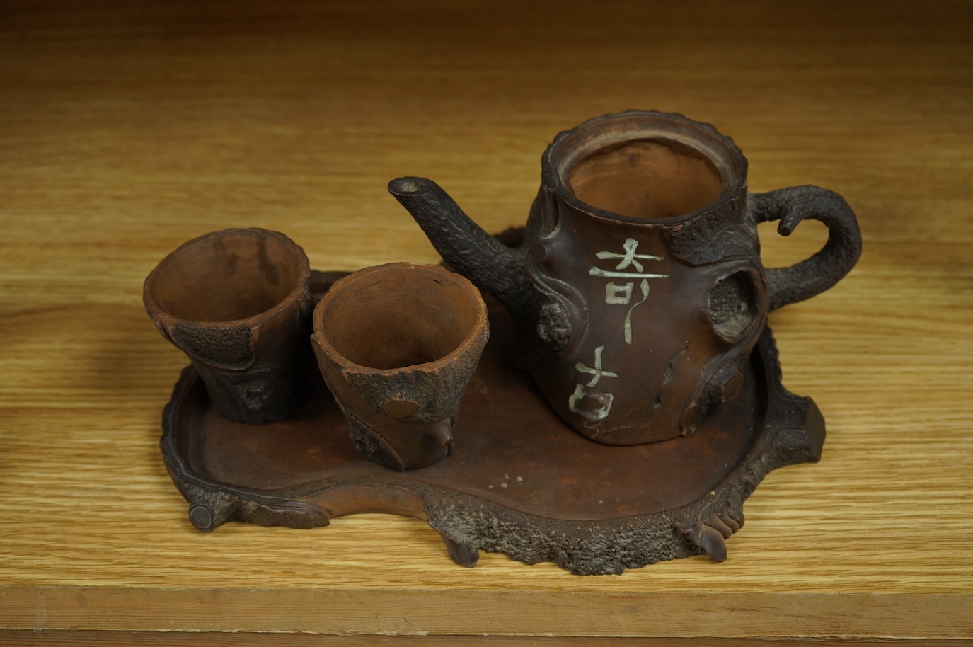 A Chinese naturalistic Yixing teapot, two cups and tray, early 20th century, 25cm high. Condition - fair/good